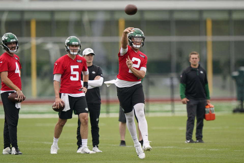 New York Jets backup quarterbacks James Morgan (4) and Mike White (5) watch quarterback Zach Wilson (2) throw a pass during an NFL football practice, Wednesday, June 2, 2021, in Florham Park, N.J. (AP Photo/Kathy Willens)