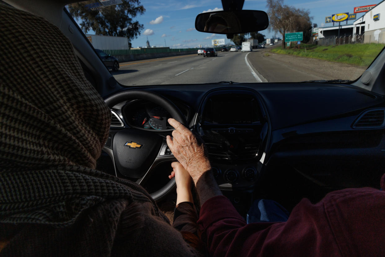 Gil Howard, un profesor jubilado que emprendió una segunda carrera como profesor de autoescuela, mantiene una mano preparada en el freno de emergencia durante una clase con Bibifatima Akhundzada al volante, en Modesto, California, el 21 de febrero de 2024. (Rachel Bujalski/The New York Times).