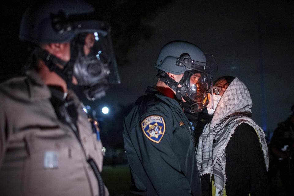 FILE - A pro-Palestinian protester confronts police as demonstrators clash at an encampment at UCLA Wednesday, May 1, 2024, in Los Angeles. (AP Photo/Ethan Swope, File)