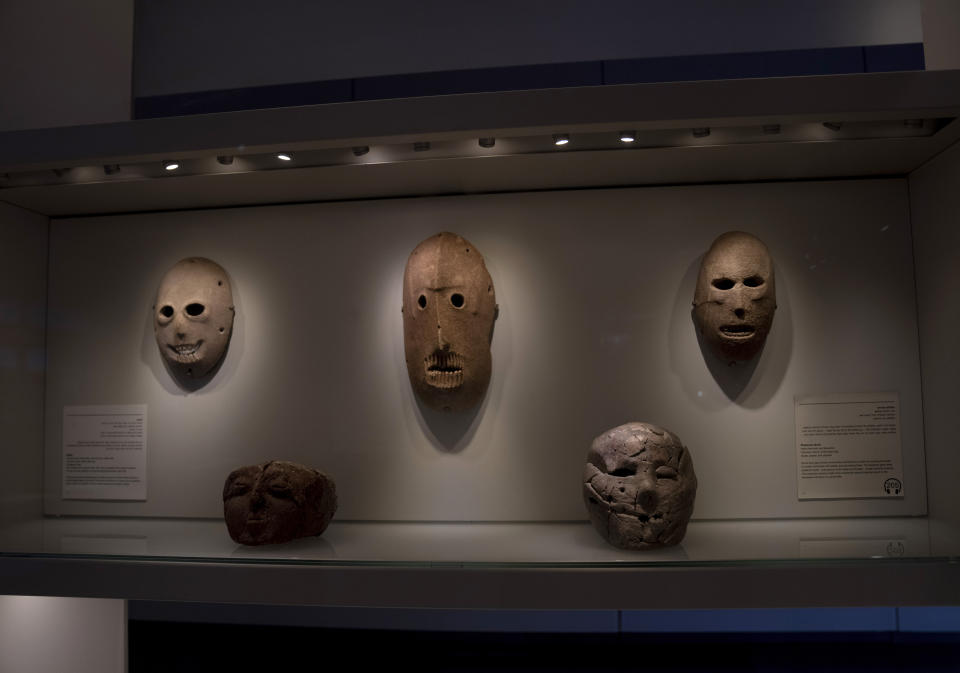 A Neolithic mask loaned by American billionaire Michael Steinhardt, center, is displayed at the Israel Museum in Jerusalem, Wednesday, Jan. 5, 2022. Last month, Steinhardt surrendered the artifact, along with 179 others valued at roughly $70 million, as part of a landmark deal with the Manhattan District Attorney's office to avoid prosecution. Eight Neolithic masks loaned by Steinhardt to the Israel Museum for a major exhibition in 2014 were also seized as part of the billionaire's deal with New York authorities. (AP Photo/Maya Alleruzzo)