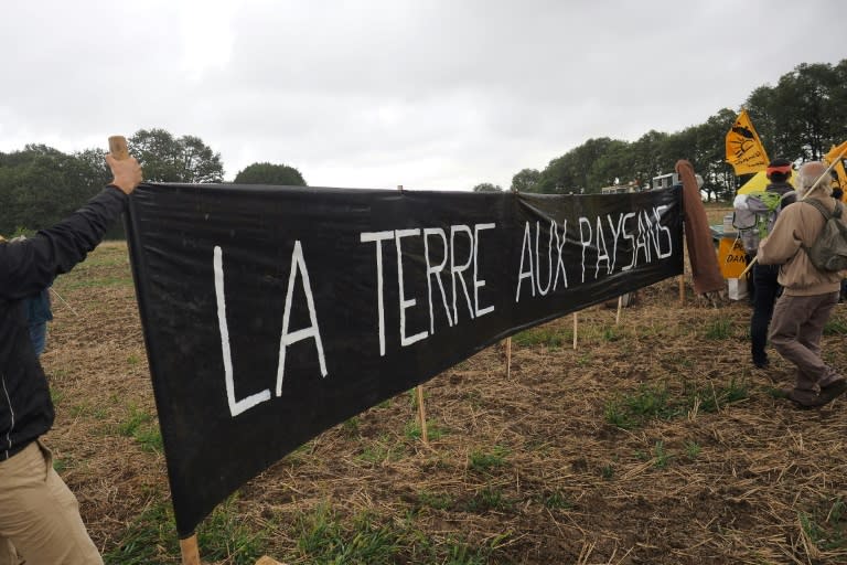 Waving the flag of France's Farmers' Confederation, they filled a seed drill with rye and sprayed grain in a demonstration they said symbolised the need to 'take back the land for the farmers'