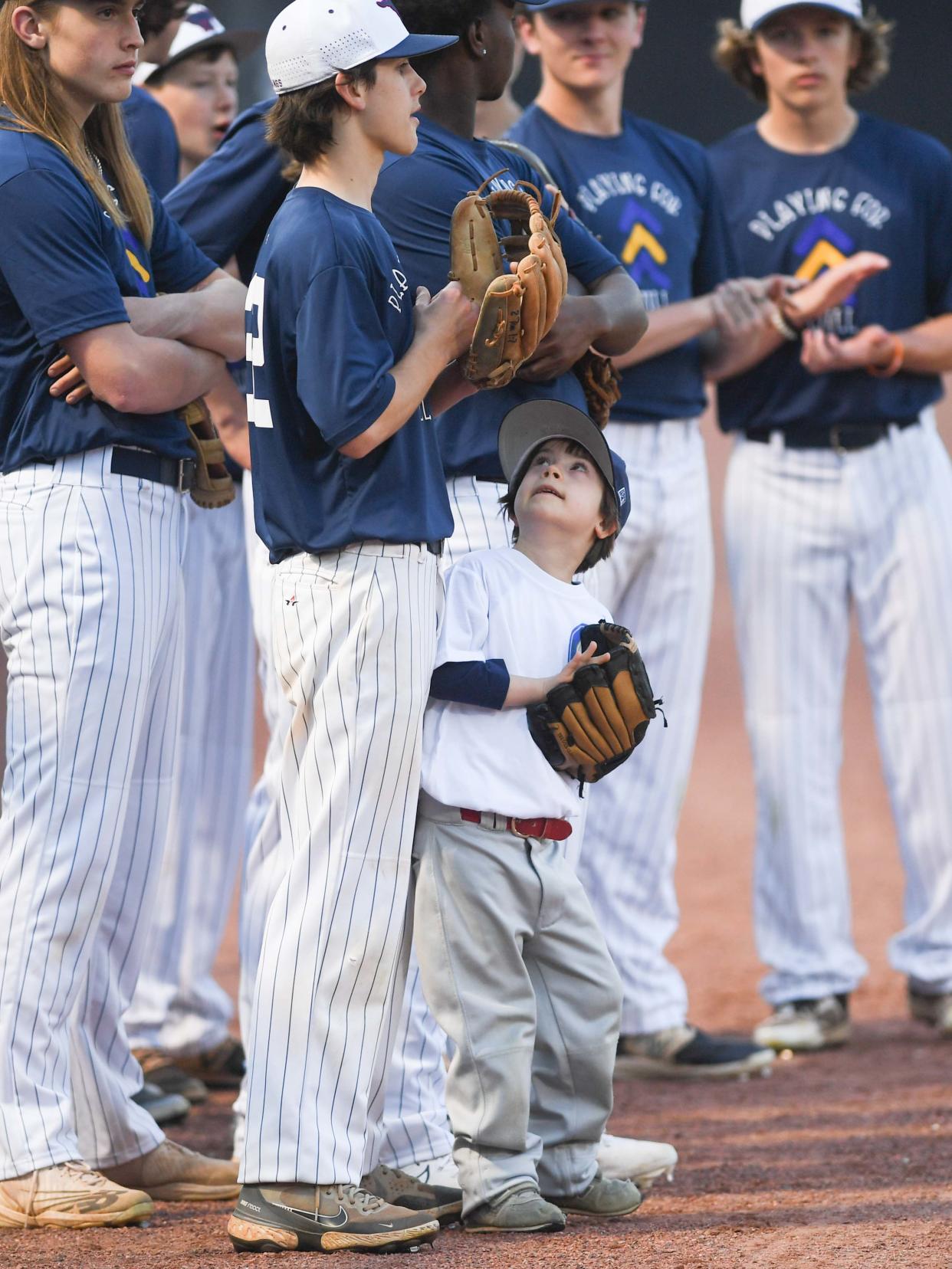 Will Clark, 7 years old with Down syndrome, looks up to his older brother Garrett as Madison starters are introduced during the WES's Game match in The Ball Park at Jackson, in Jackson, Tenn., on Thursday, March 21, 2024.
