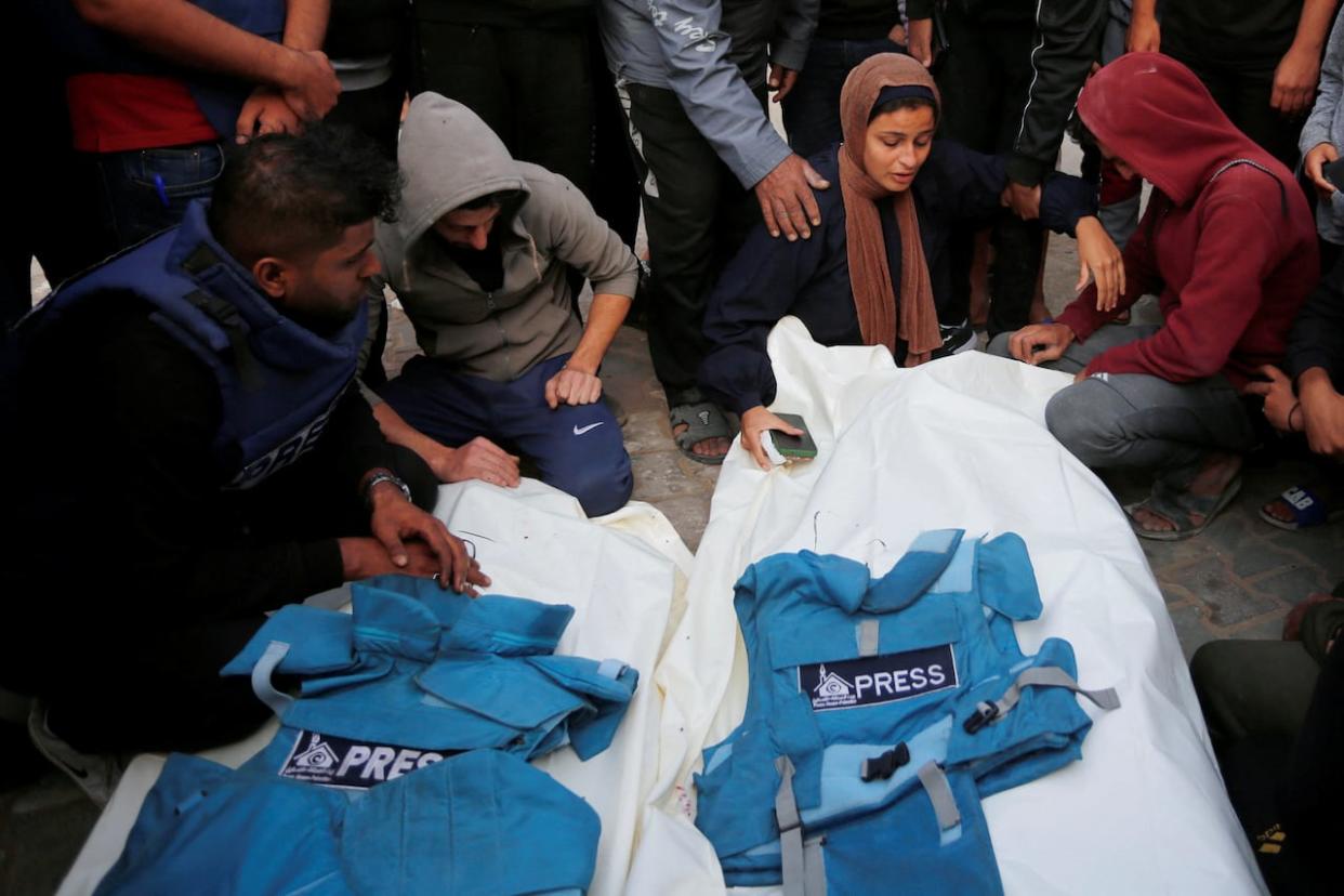 Palestinians mourn local journalists Hassouna Saliem and Sari Mansour, who were killed in an Israeli airstrike on Saturday, at a hospital in the central Gaza Strip on Sunday.  (Reuters  - image credit)