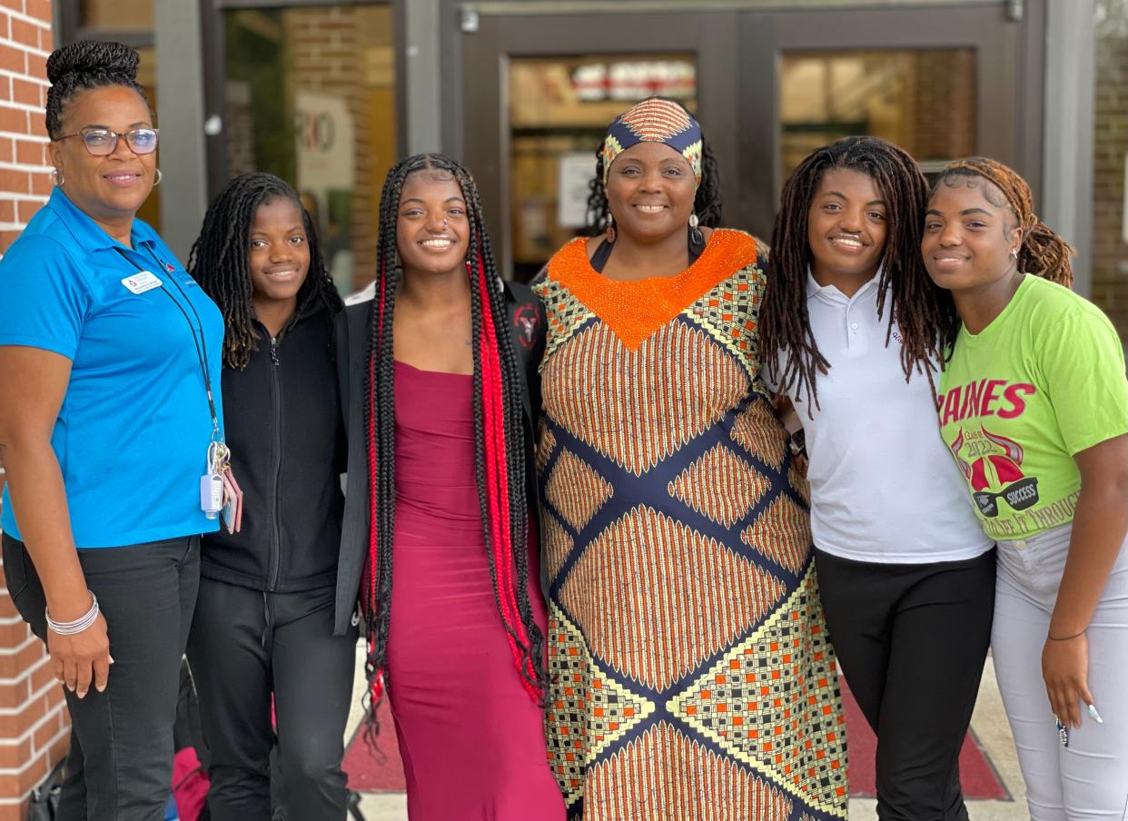 After finishing their last day at Raines High School, the Reid-El quadruplets posed for a photo with their mother, Marolotta Douglas (center), and their mentor, Jacqueline Brown (left). The sisters — from left to right and youngest to oldest (separated by 16 minutes at birth) — are Selket, Nebthet, Neith and Aset.