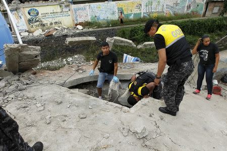 Police officers search through debris after an earthquake struck off Ecuador's Pacific coast, at Tarqui neighborhood in Manta April 17, 2016. REUTERS/Guillermo Granja