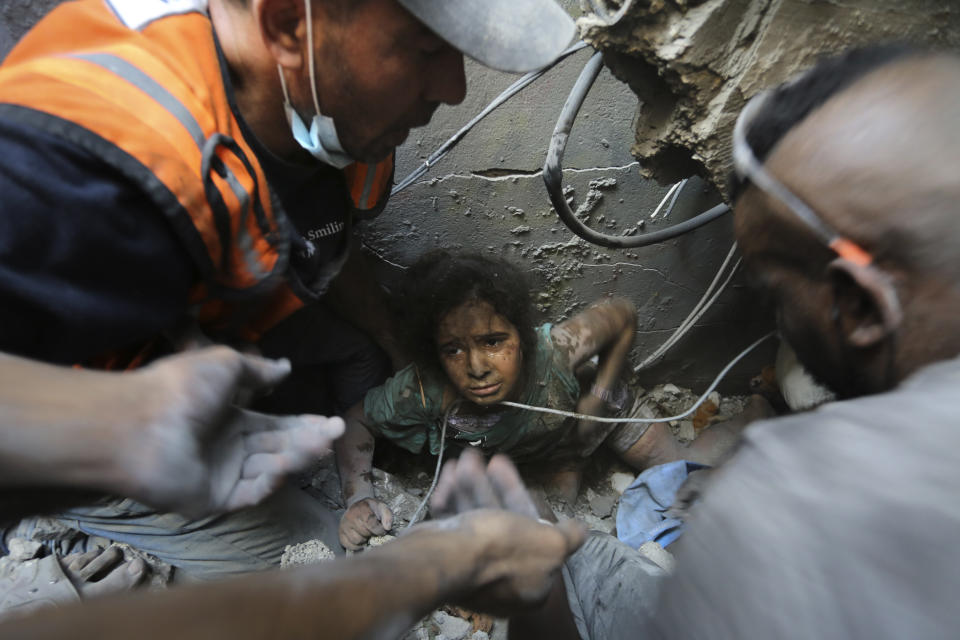Palestinians try to pull a girl out of the rubble of a building that was destroyed by Israeli airstrikes in Jabaliya refugee camp, northern Gaza Strip, Wednesday, Nov. 1, 2023. In just 25 days of war, more than 3,600 Palestinian children have been killed in Gaza, according to Gaza's Hamas-run Health Ministry. The advocacy group Save The Children says more children were killed in Gaza in October 2023 than in all conflict zones around the world combined in 2022. (AP Photo/Abed Khaled)