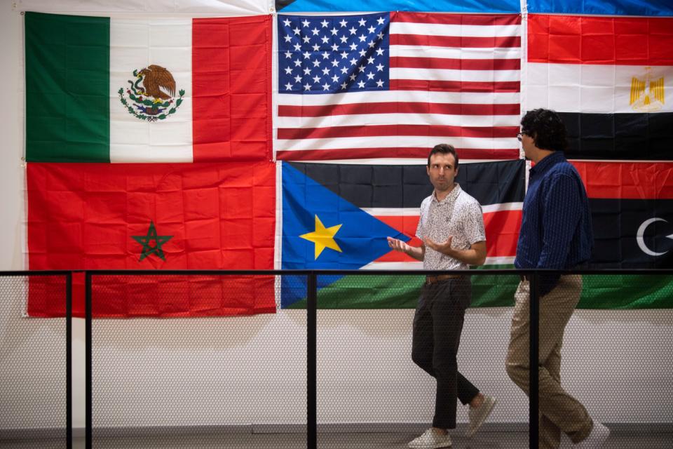 Miguel Reyna, right, a first-year math teacher, and principal Marc Gauthier walk the hallways at KIPP Antioch Global High School.