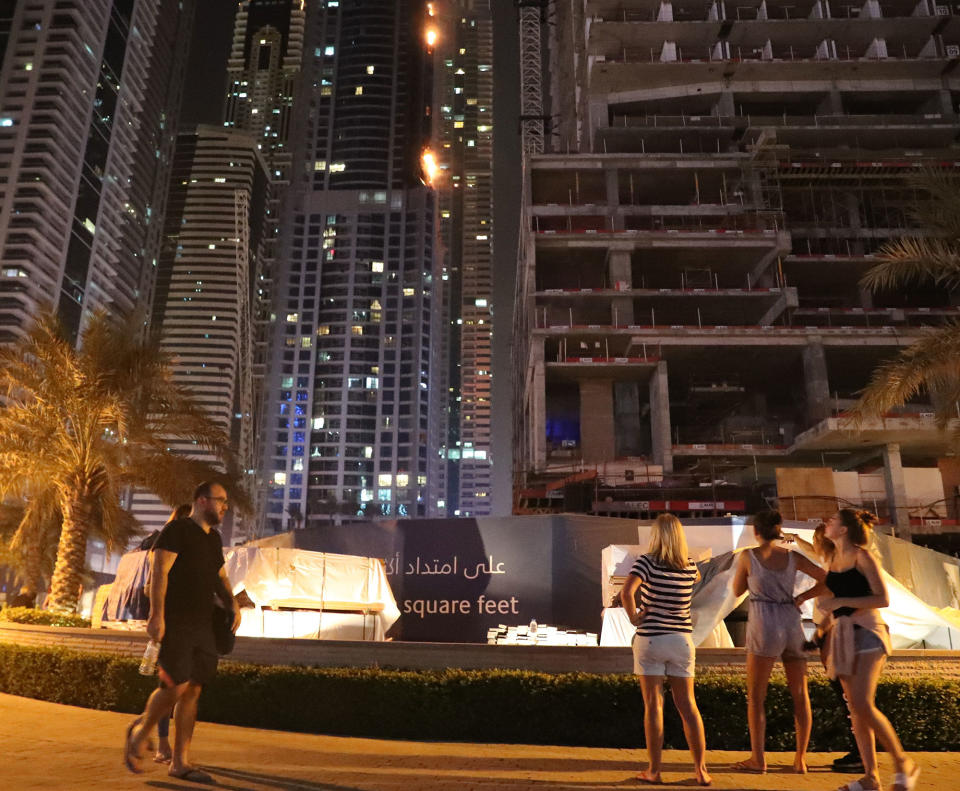 <p>People on a street view a fire at the 1,105 foot tall Torch tower skyscraper on August 4, 2017 in Dubai. (Photo: Karim Sahib/AFP/Getty Images) </p>