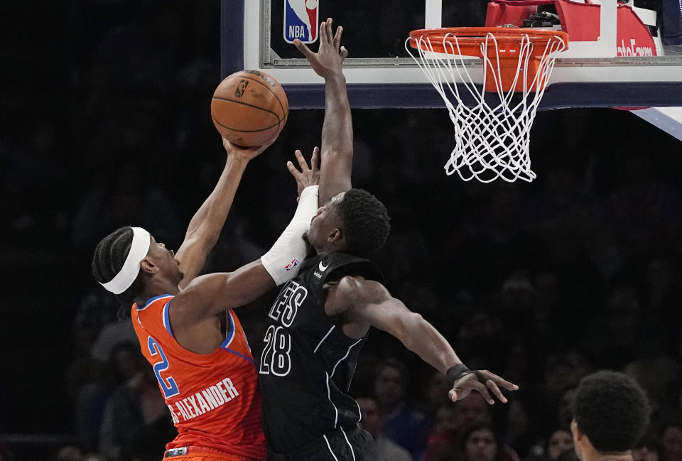 Oklahoma City Thunder guard Shai Gilgeous-Alexander (2) shoots as Brooklyn Nets forward Dorian Finney-Smith (28) defends in the first half of an NBA basketball game Tuesday, March 14, 2023, in Oklahoma City. (AP Photo/Sue Ogrocki)