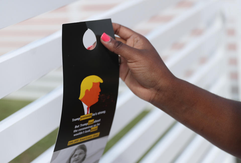 MIAMI GARDENS, FLORIDA - OCTOBER 06: Bettylourde Guerrier places a campaign flyer on a fence as she canvasses a neighborhood encouraging people to vote for Democratic presidential nominee Joe Biden who is running against President Donald Trump on October 06, 2020 in Miami Gardens, Florida. UNITE HERE coordinated the canvassing effort as they lead a statewide effort to mobilize voters before the November 3rd election. UNITE HERE Florida is a labor union that represents over 34,000 workers in the hotel, casino, food service, and airport industries in Central and South Florida. (Photo by Joe Raedle/Getty Images)