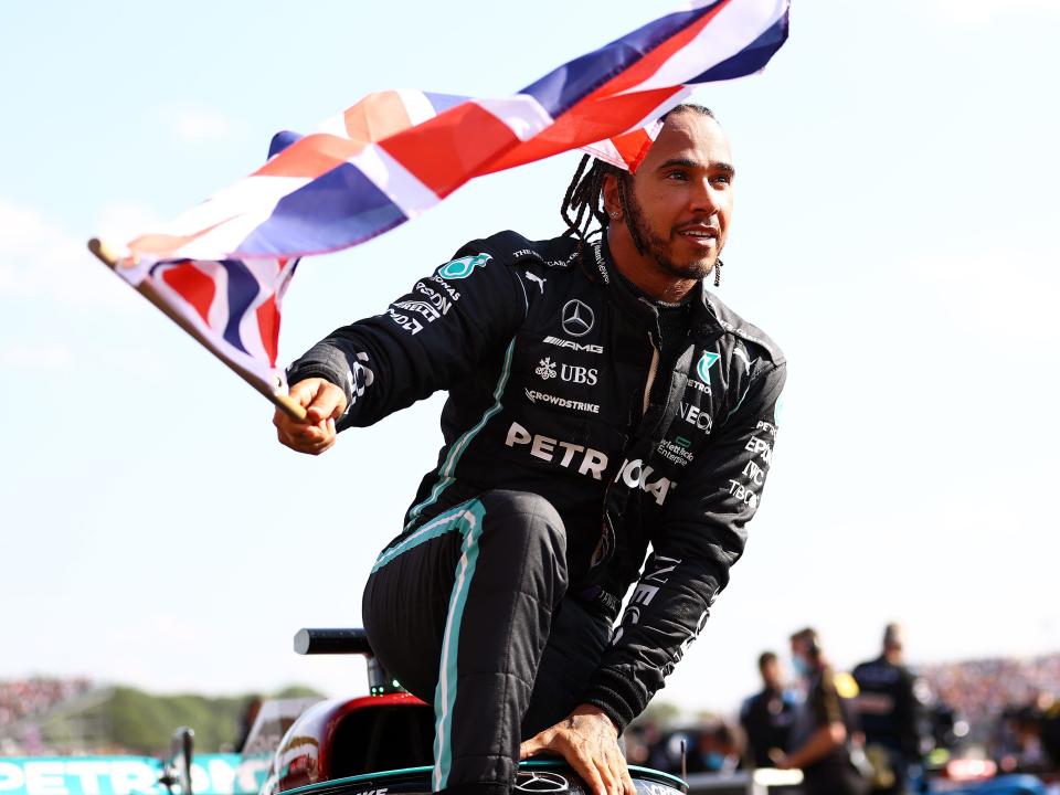 Lewis Hamilton waves a British flag at the British Grand Prix