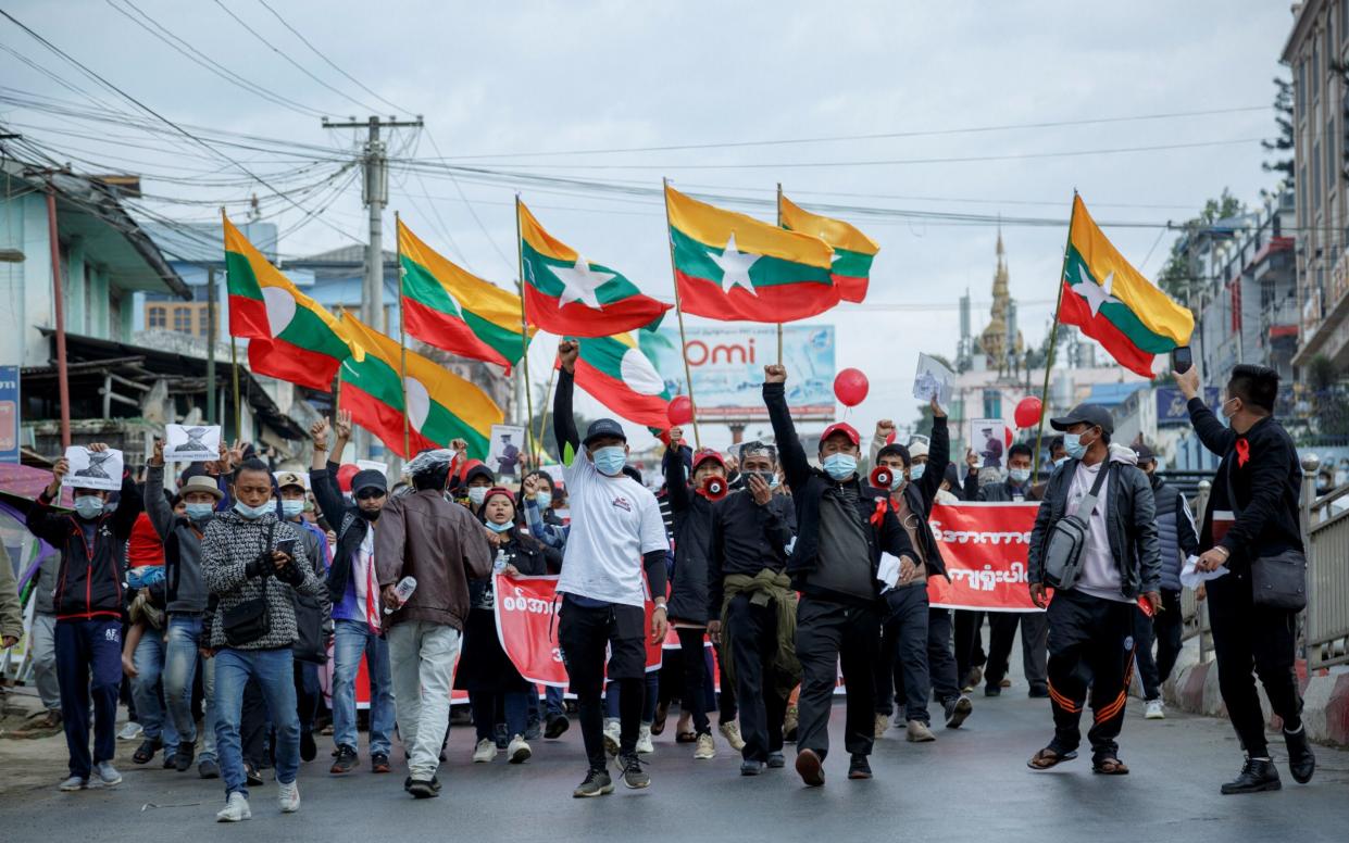 People take part in a demonstration against the February 1 military coup, along a street in the town of Muse in Shan state, near the China-Myanmar border on Feb 8 2021