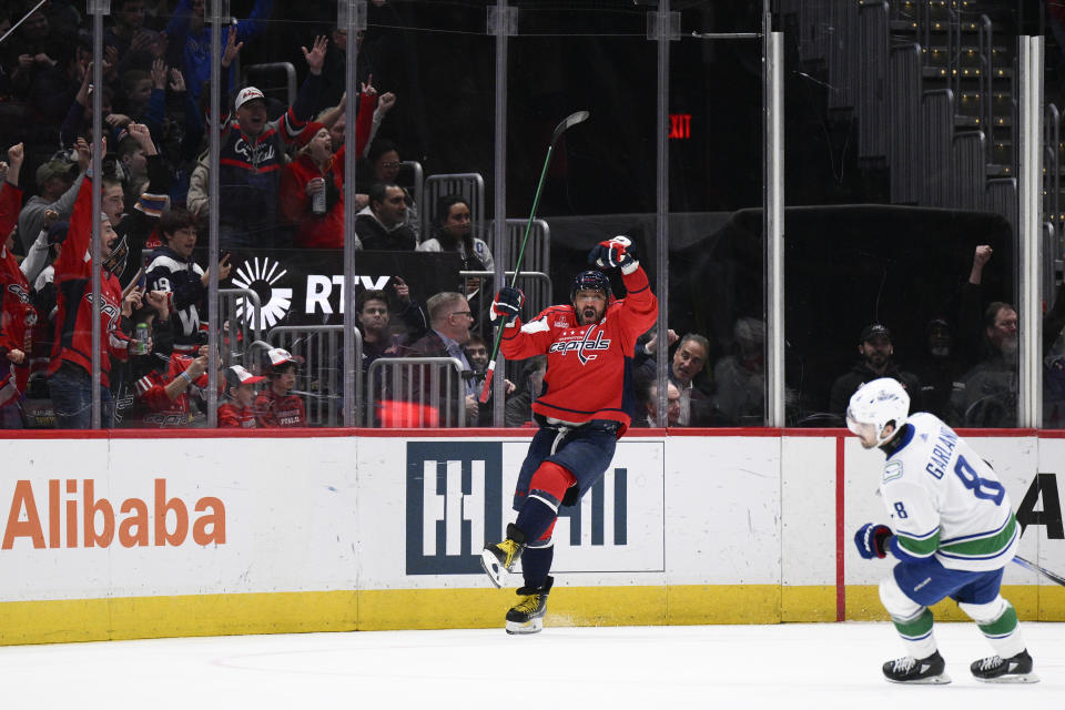 Washington Capitals left wing Alex Ovechkin, left, celebrates after his goal during the second period of an NHL hockey game against the Vancouver Canucks, Sunday, Feb. 11, 2024, in Washington. Canucks right wing Conor Garland, right, looks on. (AP Photo/Nick Wass)