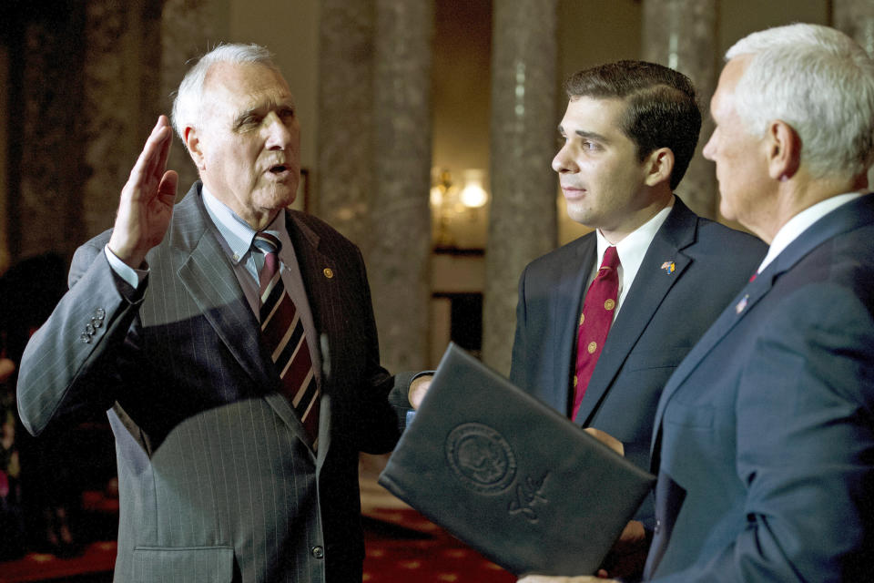 FILE - In this Sept. 5, 2018 file photo, Vice President Mike Pence, right, administers the oath of office to Sen. Jon Kyl, R-Ariz., while his grandson Christopher Gavin holds a Bible, during a ceremonial swearing-in at the Old Senate Chamber on Capitol Hill in Washington. Arizona Gov. Doug Ducey announced Friday, Dec. 14, Kyl will resign at the end of the year from the U.S. Senate seat he was appointed to less than four months ago following the death of Sen. Jon McCain. (AP Photo/Cliff Owen, File)