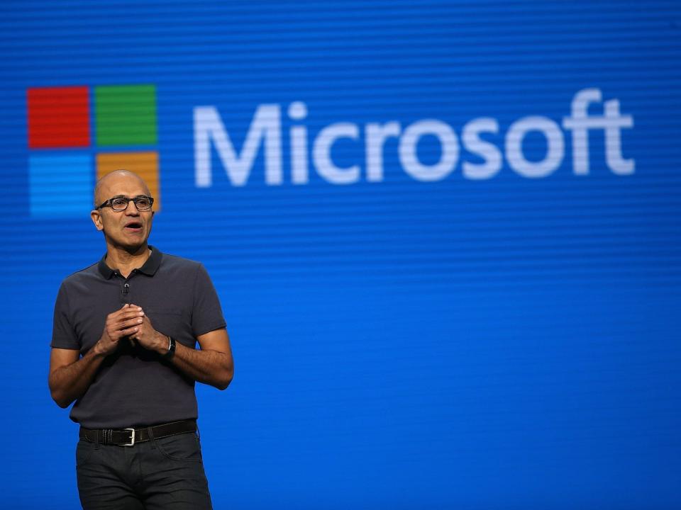 Microsoft CEO Satya Nadella with the word "Microsoft" and the Microsoft logo displayed behind him