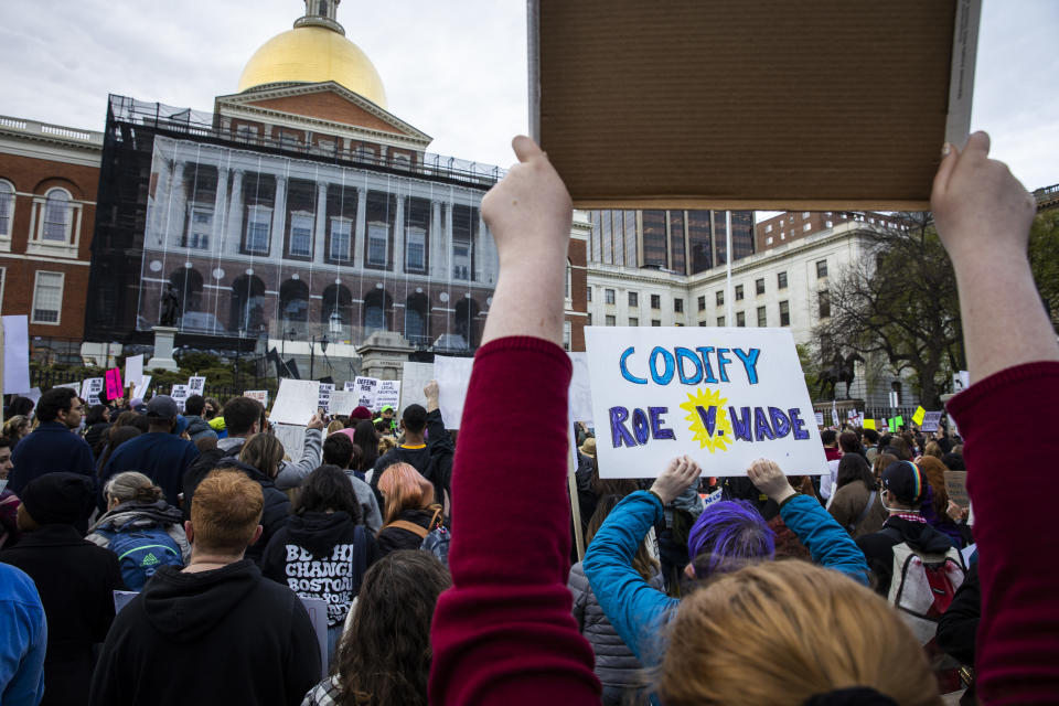 A person holds a sign calling for the codification of Roe v. Wade during a protest at the Massachusetts State House in Boston on Tuesday. (Erin Clark/The Boston Globe via Getty Images)