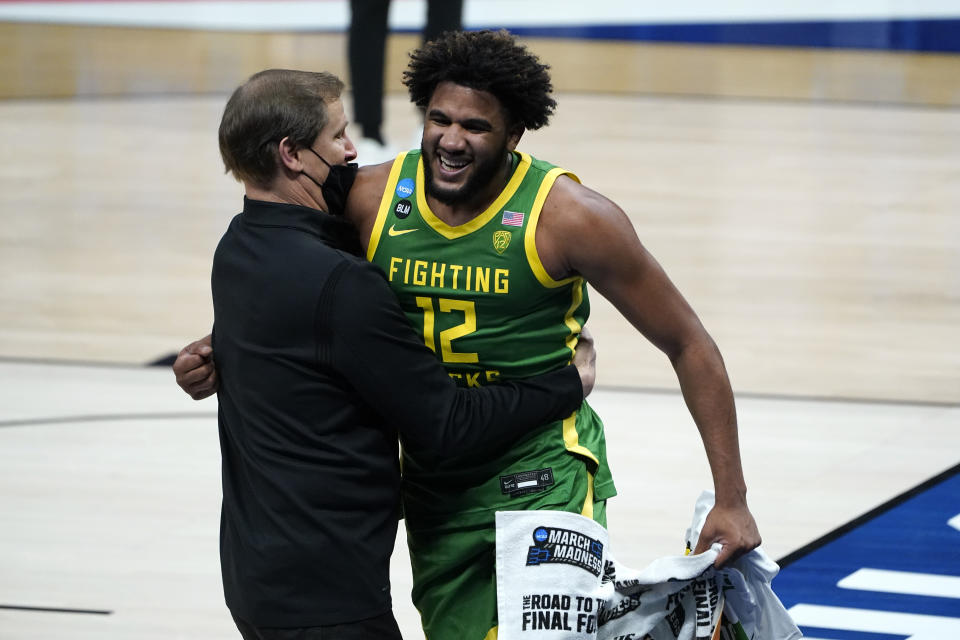 Oregon head coach Dana Altman and LJ Figueroa (12) celebrate after beating Iowa 95-80 in a men's college basketball game in the second round of the NCAA tournament at Bankers Life Fieldhouse in Indianapolis, Monday, March 22, 2021. (AP Photo/Paul Sancya)