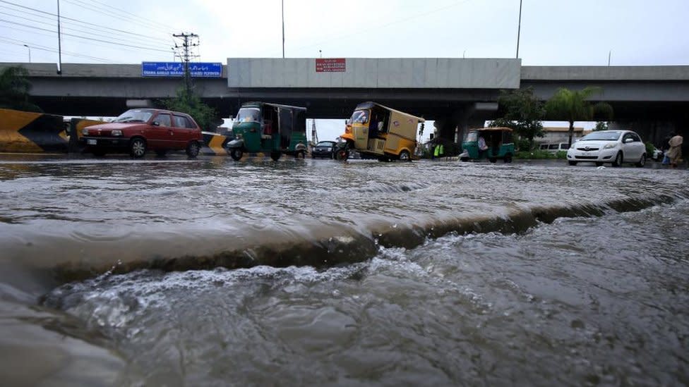 People make their way during heavy rain in Peshawar, Pakistan