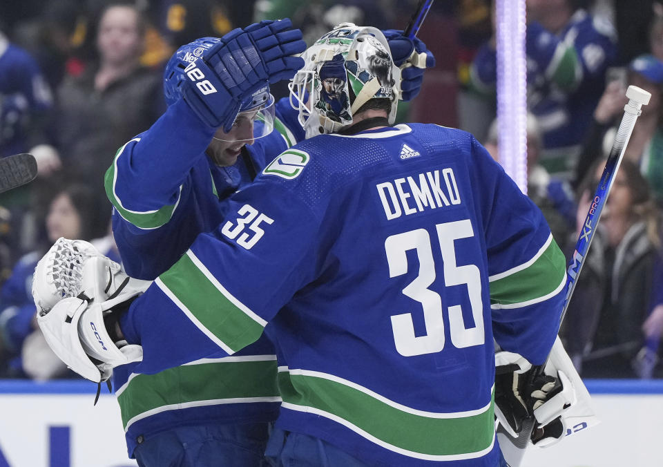 Vancouver Canucks' Ilya Mikheyev, left, and goalie Thatcher Demko celebrate the team's win over the Calgary Flames in an NHL hockey game Tuesday, April 16, 2024, in Vancouver, British Columbia. (Darryl Dyck/The Canadian Press via AP)