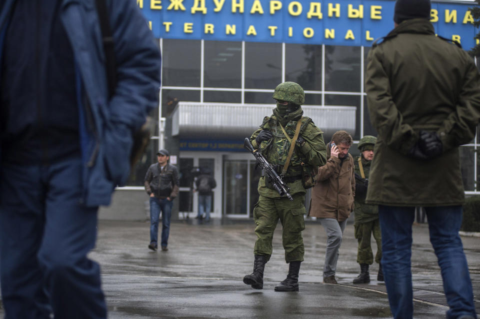 Unidentified armed man patrols a square in front of the airport in Simferopol, Ukraine, Friday, Feb. 28, 2014. Dozens of armed men in military uniforms without markings patroled the airport in the capital of Ukraine's strategic Crimea region on Friday as tensions in the country's Russian-speaking southeast escalated. (AP Photo/Andrew Lubimov)