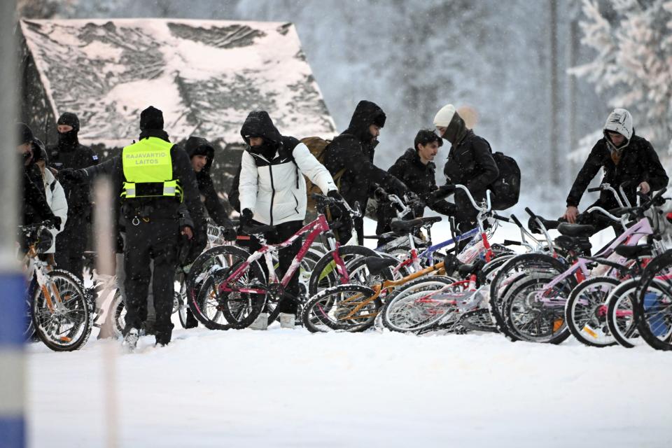 Migrants arrive with bicycles at the international border crossing between Finland and Russia, in Salla, Finland, Thursday, Nov. 23, 2023. (Jussi Nukari/Lehtikuva via AP)