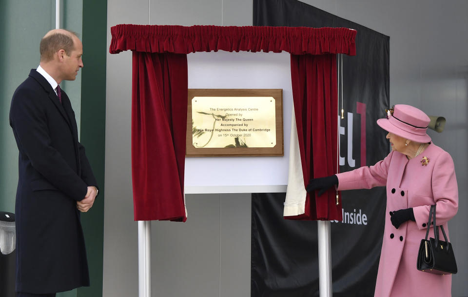 Britain's Prince William looks on as Queen Elizabeth II unveils a plaque to officially open the new Energetics Analysis Centre at the Defence Science and Technology Laboratory (DSTL) at Porton Down, England, Thursday Oct. 15, 2020, to view the Energetics Enclosure and display of weaponry and tactics used in counter intelligence. (Ben Stansall/Pool via AP)