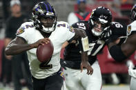 Baltimore Ravens quarterback Tyler Huntley (2) scrambles as Arizona Cardinals linebacker Cameron Thomas (97) pursues during the first half of an NFL preseason football game, Sunday, Aug. 21, 2022, in Glendale, Ariz. (AP Photo/Rick Scuteri)