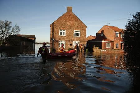 Members of the emergency services rescue people from a flooded street in Naburn, northern England, December 27, 2015. REUTERS/Phil Noble