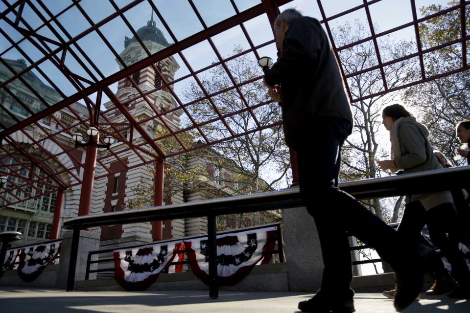 Some of the first visitors to the newly re-opened Ellis Island make their way inside in New York, Monday, Oct. 28, 2013. The island that ushered millions of immigrants into the United States received visitors Monday for the first time since Superstorm Sandy. Sandy swamped boilers and electrical systems and left the 27.5-acre island without power for months. (AP Photo/Seth Wenig)