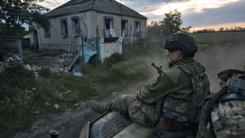 A Ukrainian soldier rides atop an armored personnel carrier, or APC, on the frontline in the Luhansk region, Ukraine, on Sunday, May 21, 2023.