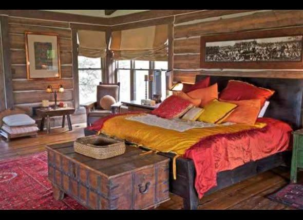 This cozy bedroom with bright, colorful bedding and an antique chest has a cabin-lodge appeal.