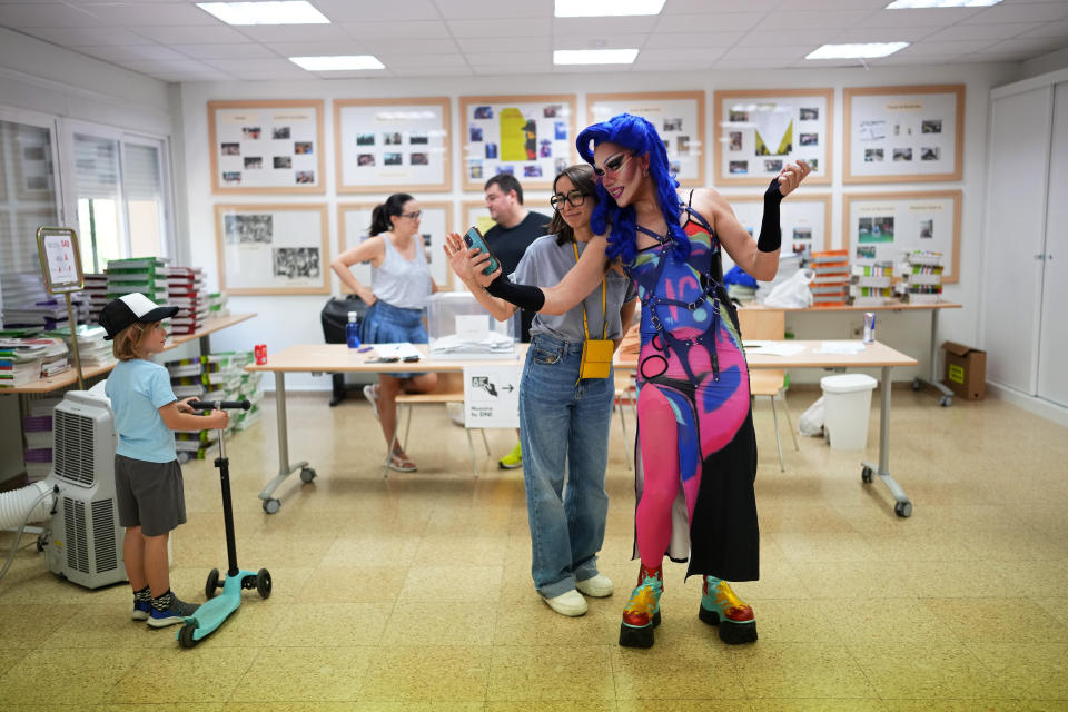 A voter poses for a selfie with Onyx, right, a drag queen doing election work at a polling station for Spain's general election, in Madrid, Sunday, July 23, 2023. Sunday's election could make the country the latest European Union member to swing to the populist right, a shift that would represent a major upheaval after five years under a left-wing government. (AP Photo/Manu Fernandez)