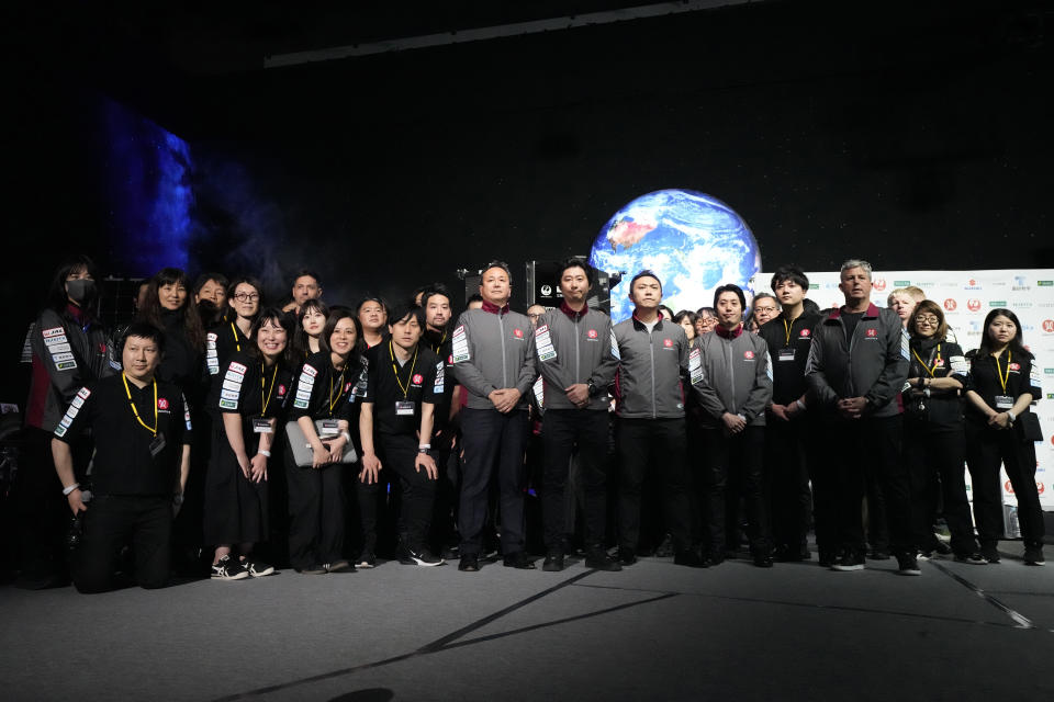 Staff of ispace gather for photo session at the end of livestream of HAKUTO-R private lunar exploration program on screen at the lunar landing event Wednesday, April 26, 2023, at Miraikan, the National Museum of Emerging Science and Innovation, in Tokyo. Tokyo's ispace tried to land its own spacecraft on the moon early on Wednesday, but its fate was unknown as flight controllers lost contact with it moments before the planned touchdown. (AP Photo/Eugene Hoshiko)