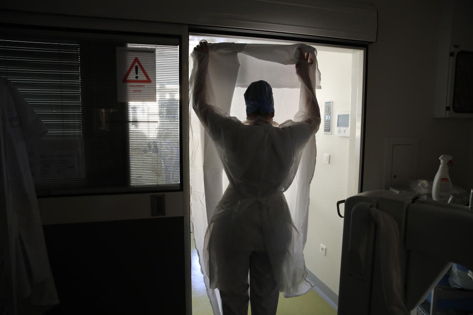A medical worker prepares to tend to patients affected with the COVID-19 in the Amiens Picardie hospital Tuesday, March 30, 2021 in Amiens, 160 km (100 miles) north of Paris. The number of patients in intensive care in France on Monday surpassed the worst point of the country's last coronavirus surge in the autumn of 2020, another indicator of how a renewed crush of infections is bearing down on French hospitals. (AP Photo/Francois Mori)