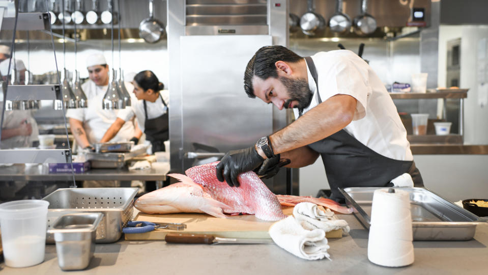 Chef Aaron Bludorn fileting fish