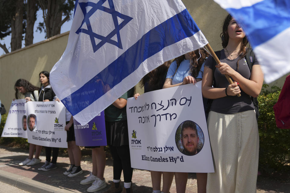 People line the street outside of the funeral of Elan Ganeles, 27, a dual U.S.-Israeli citizen from West Hartford, Connecticut, in Raanana, Israel, Wednesday, March 1, 2023. The Israeli army said a suspected Palestinian gunman opened fire on Tuesday at an Israeli car near the Palestinian city of Jericho, hitting Ganeles. A friend told local media he had been visiting Israel for a wedding and driving on a highway near the Dead Sea when he was shot. Hebrew reads: "The eternal people do not fear the long road." (AP Photo/Tsafrir Abayov)