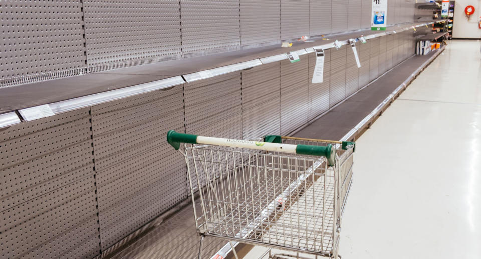 Empty toilet paper shelf at Woolworths with empty trolley