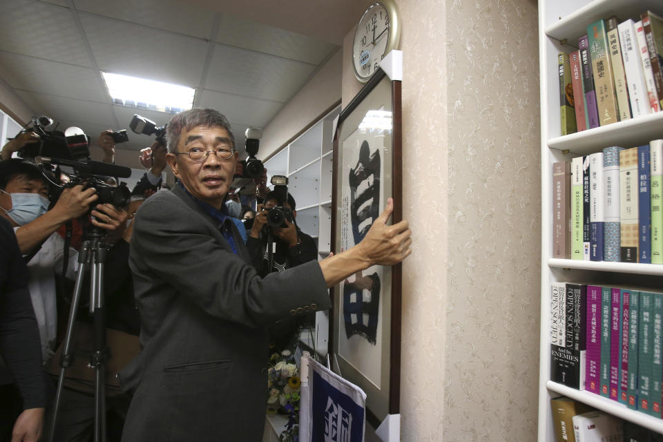 Lam Wing-kee, one of five shareholders and staff at the Causeway Bay Book shop in Hong Kong, hangs his congratulatory gift, Chinese calligraphy that reads: ''Freedom'' at his new book shop on the opening day in Taipei, Taiwan, Saturday, April 25, 2020. The part-owner of the Hong Kong bookstore specializing in texts critical of China’s leaders reopened his shop in Taiwan on Saturday after fleeing Hong Kong due to legal troubles, saying he was grateful for the opportunity to make China's Communist rulers “less than happy." (AP Photo/Chiang Ying-ying)