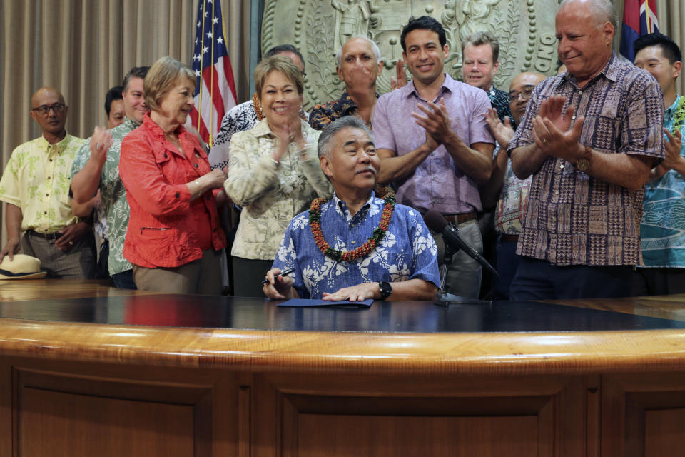 FILE - In this Wednesday, June 13, 2018, file photo, Hawaii lawmakers applaud in Honolulu after Hawaii Gov. David Ige signs legislation in banning a pesticide scientists have found could hinder the development of children's brains. Ige and state lawmakers say Hawaii is the first state to ban chlorpyrifos. The widely used agricultural pesticide chlorpyrifos that California environmental officials have said has been linked to brain damage in children will be banned after next year under an agreement reached with the manufacturer, state officials announced Wednesday, Oct. 9, 2019. (AP Photo/Audrey McAvoy, File)