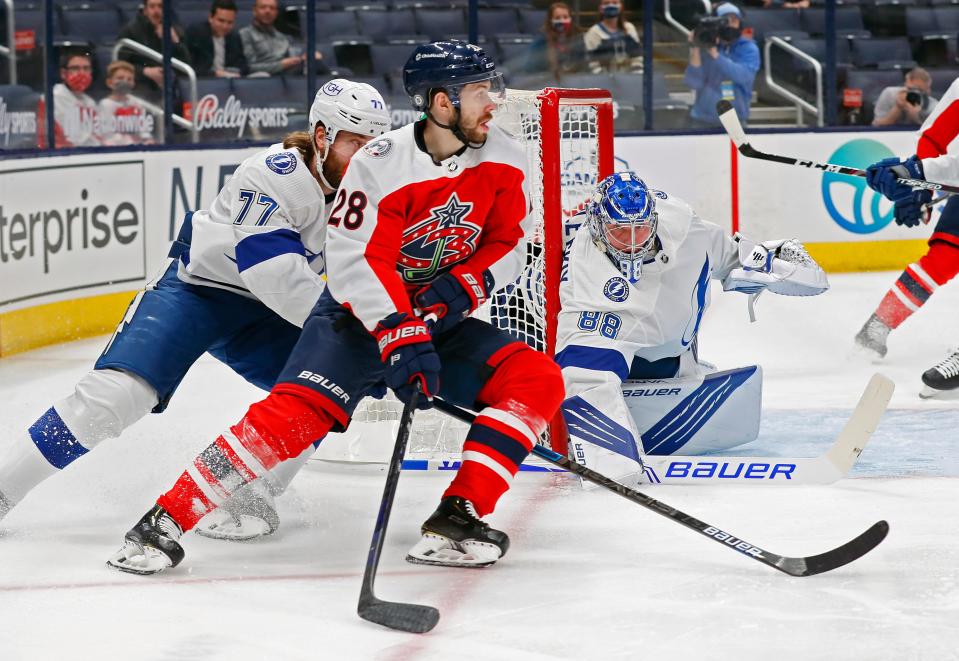 Columbus Blue Jackets right wing Oliver Bjorkstrand (28) looks to pass the puck against Tampa Bay Lightning defenseman Victor Hedman (77) in the first period of their NHL game at Nationwide Arena in Columbus, Ohio on April 6, 2021. 