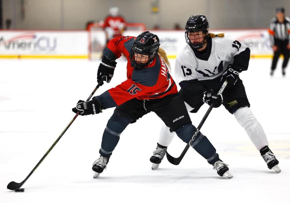 PWHL Ottawa defender Savannah Harmon keeps the puck away from an opponent with Minnesota.