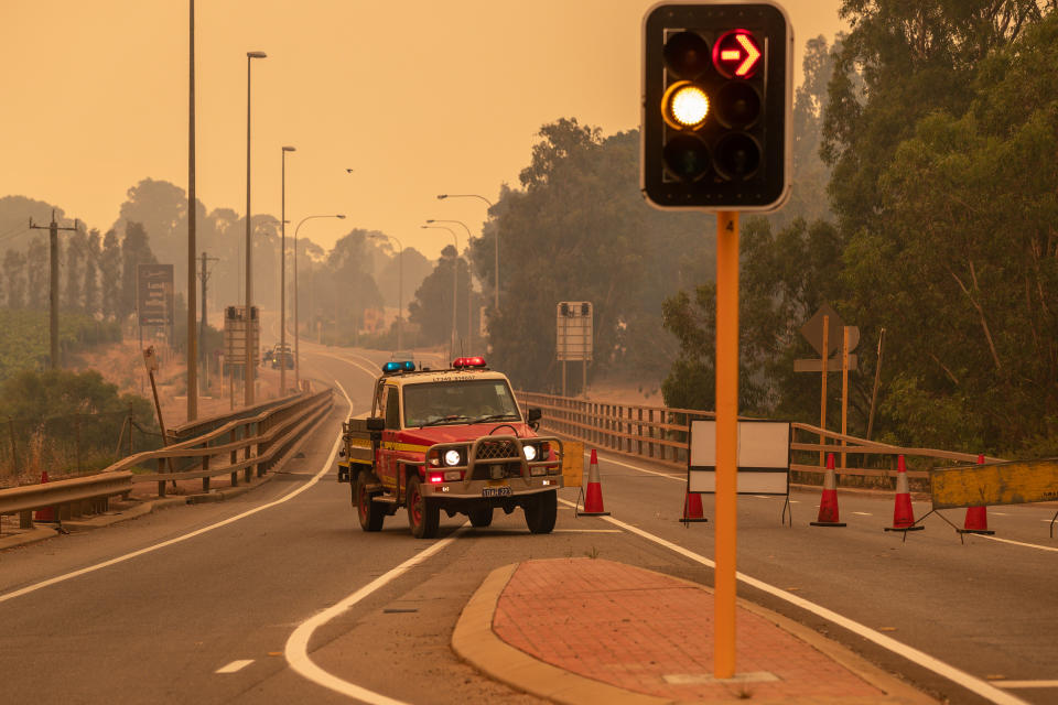 Emergency vehicles block a road heading towards the fire. Source: AAP