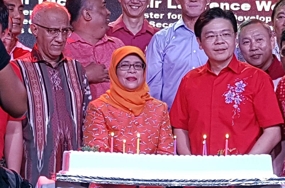 Speaker of Parliament Halimah Yacob (centre), her husband Mohammed Abdullah Alhabshee (left) and Minister for National Development Lawrence Wong at the Marsiling National Day Celebration event on Sunday (6 August). (PHOTO: Safhras Khan / Yahoo News Singapore)