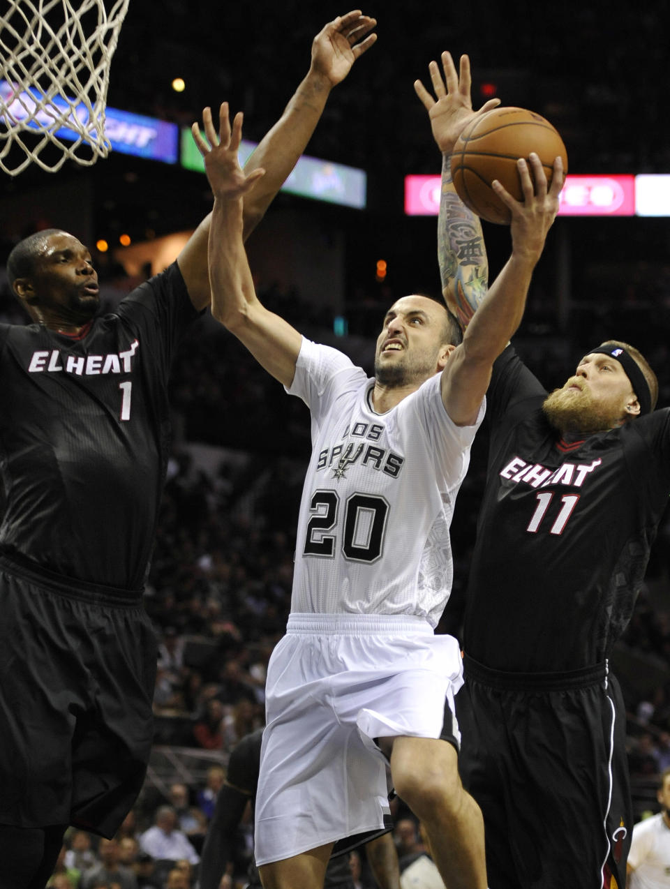 San Antonio Spurs guard Manu Ginobili, center, of Argentina, shoots against Miami Heat forwards Chris Bosh, left, and Chris Andersen, during the first half of an NBA basketball game on Thursday, March 6, 2014, in San Antonio. (AP Photo/Darren Abate)