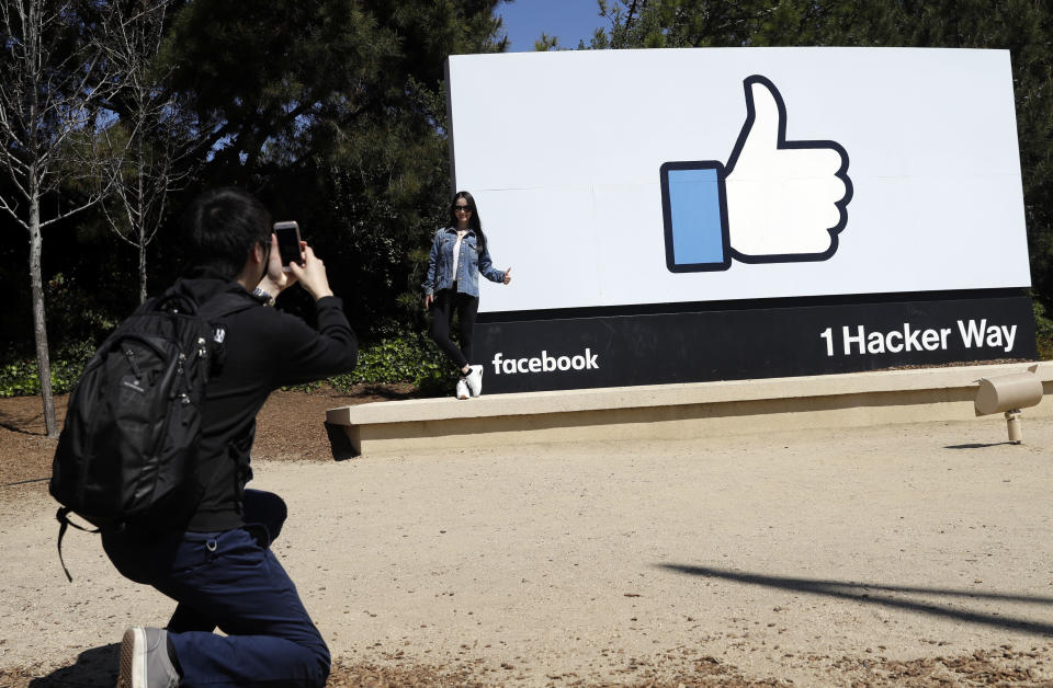 Visitors take photos in front of the Facebook logo at the company's headquarters Wednesday, March 28, 2018, in Menlo Park , Calif. (AP Photo/Marcio Jose Sanchez)