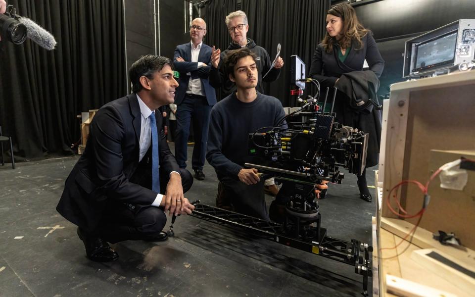 Rishi Sunak, the Prime Minister, watches student cinematographer Christopher Hudson operate a camera on a model set created by students, during a visit to the National Film and Television School based at Beaconsfield Studios in Buckinghamshire