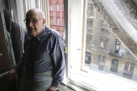 Resident Tamas Marton, 84, stands at the window of his apartment in a building where the Open Society Archives organises a Holocaust commemoration in downtown Budapest, June 21, 2014. REUTERS/Marton Dunai