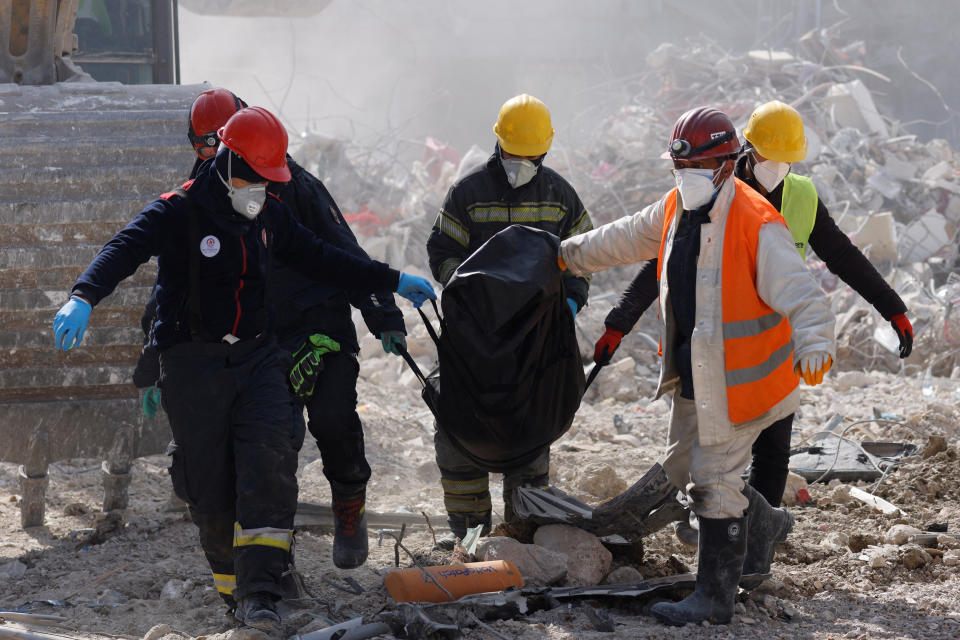 Rescuers carry a body of a victim of a deadly earthquake in Antakya, Turkey February 16, 2023. REUTERS/Maxim Shemetov