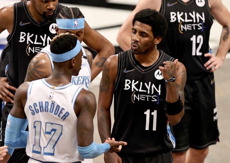 The Lakers' Dennis Schroder (17) and the Nets' Kyrie Irving (11) have words in the third quarter April 10, 2021.