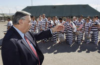 FILE - In this Feb. 4, 2009, file photo, Maricopa County Sheriff Joe Arpaio, left, orders approximately 200 convicted illegal immigrants handcuffed together and moved into a separate area of Tent City, for incarceration until their sentences are served and they are deported to their home countries, in Phoenix. Joe Arpaio is running again to get back his old job as sheriff of metro Phoenix. His 24 years as sheriff were defined by a series of tough-on-crime tactics and legal problems that cost taxpayers millions of dollars. (AP Photo/Ross D. Franklin, File)